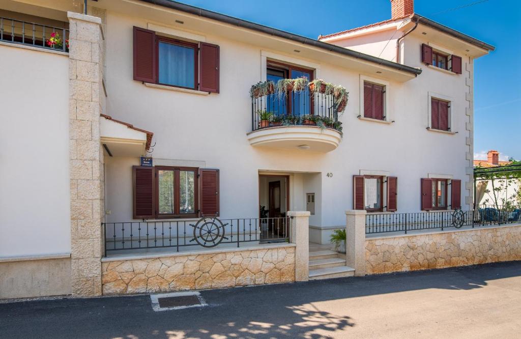 a large white house with a balcony at Apartmani Josip in Porat