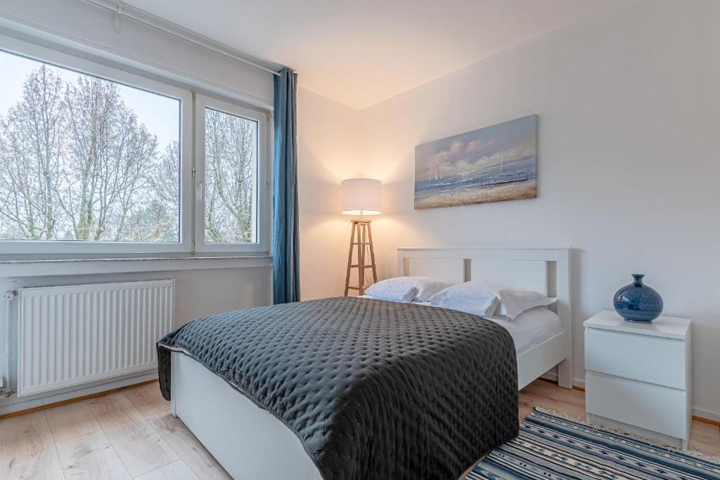 a bedroom with a bed and a large window at Les Trois Frontières in Terville