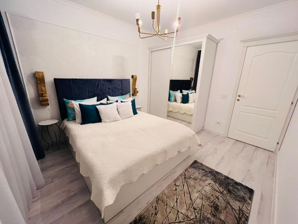 um quarto com uma cama grande e uma cabeceira azul em Apartament Larysse em Oradea