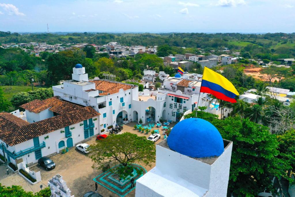 une vue aérienne sur un bâtiment blanc avec drapeau dans l'établissement Hotel Aldea Plaza, à Doradal