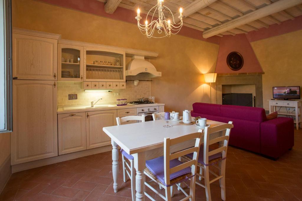 a kitchen and dining room with a table and a purple couch at Podere San Pietro Resort in Castiglion Fibocchi