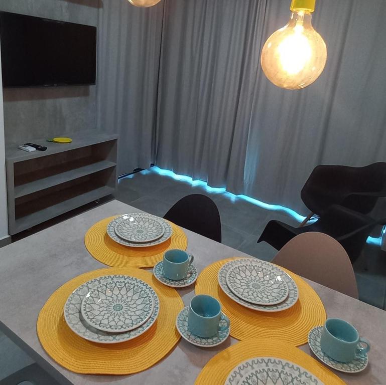 una mesa de comedor con platos y platos. en Maracaipe condomínio novo, apartamento 103, en Porto de Galinhas