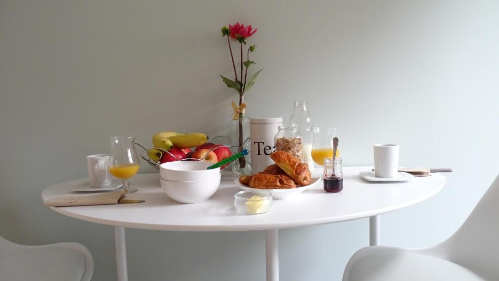 a white table with breakfast foods and drinks on it at Côté Grange in Tournai