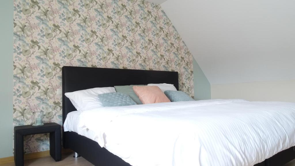 a white bed with pillows on it in a bedroom at Côté Grange in Tournai