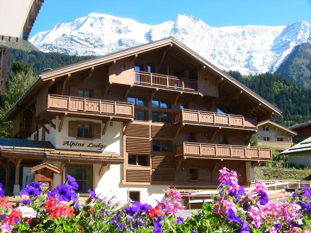 a large building with mountains in the background at Alpine Lodge 1 in Les Contamines-Montjoie