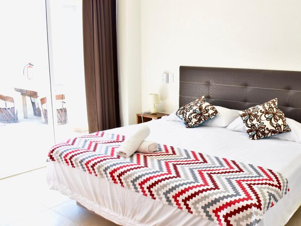 a bedroom with a large bed with a blanket on it at Carri Surf Studio in Puerto Escondido