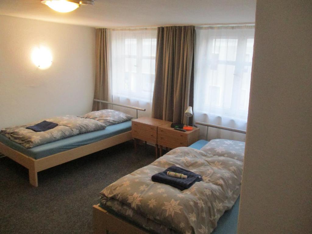 Habitación de hotel con 2 camas y ventana en Ferienzimmer Monteurzimmer Stadtmitte Nördlingen en Nördlingen