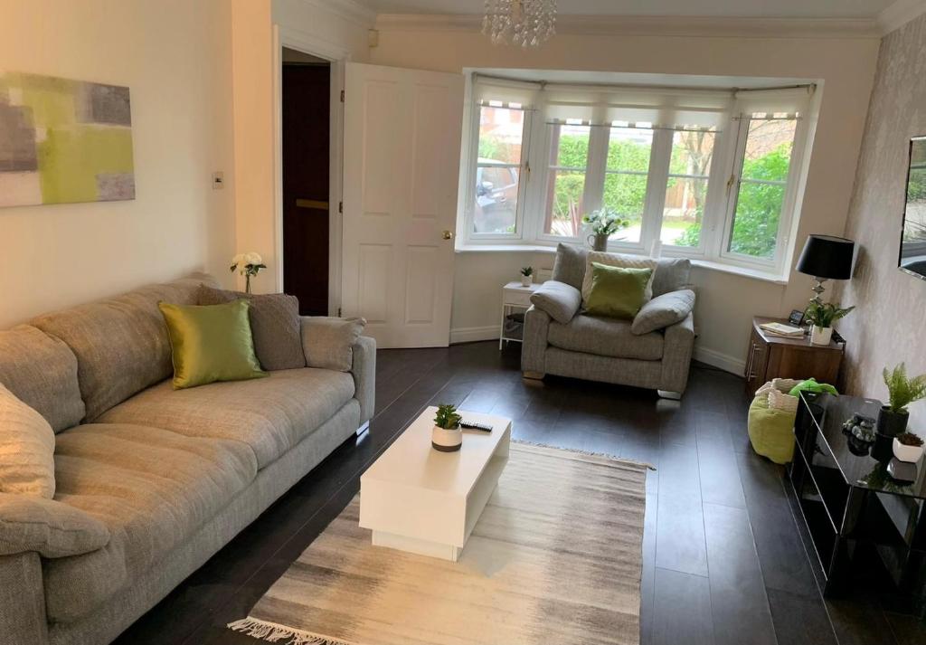 un soggiorno con divano e tavolo di Spacious and amazing 4 bedroom detached house a Manchester