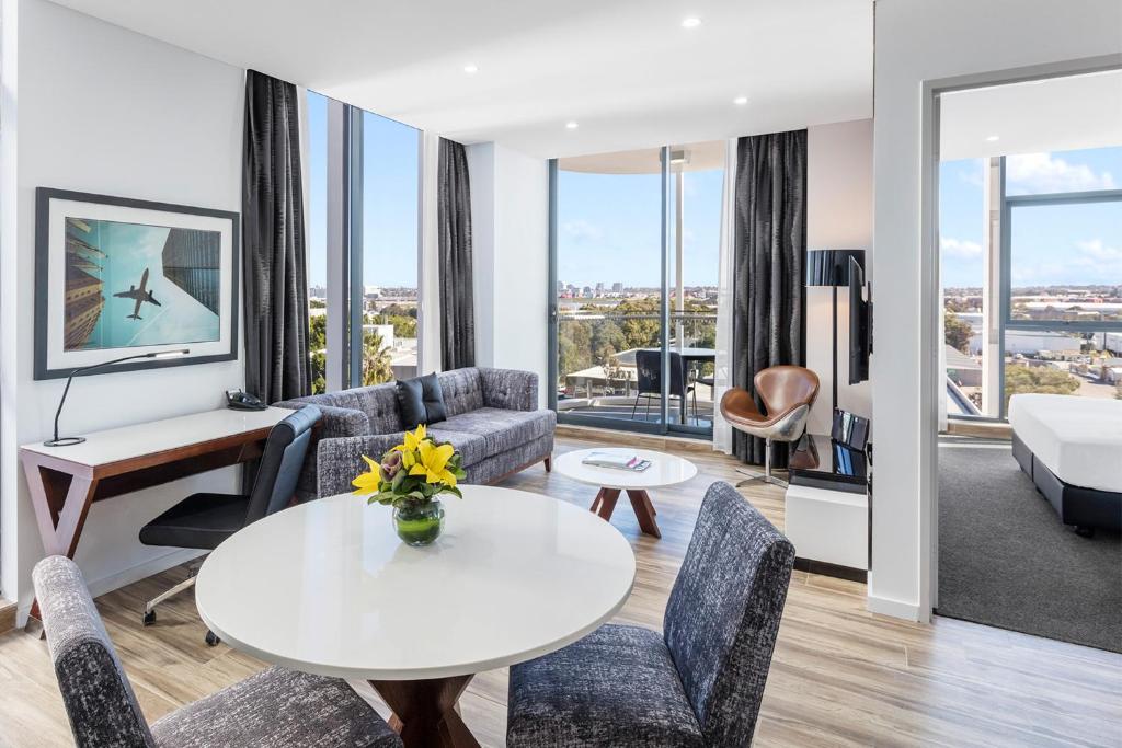 a living room filled with furniture and a large window at Meriton Suites Mascot Central in Sydney