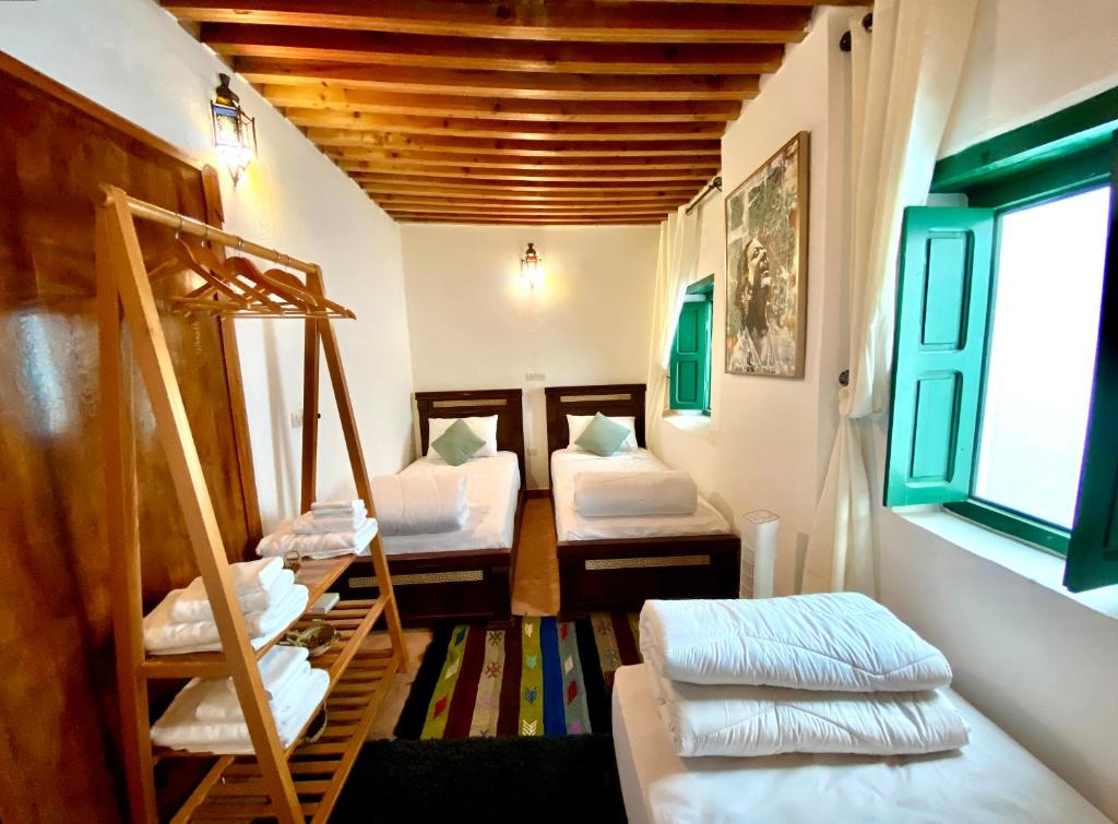 a room with three bunk beds and a window at Riad & Café culturel BAB EL FAN in Tetouan