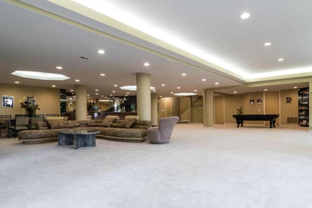 een grote lobby met banken en een piano bij Nature living Luxury private Home pristine lake in Wolverine Lake