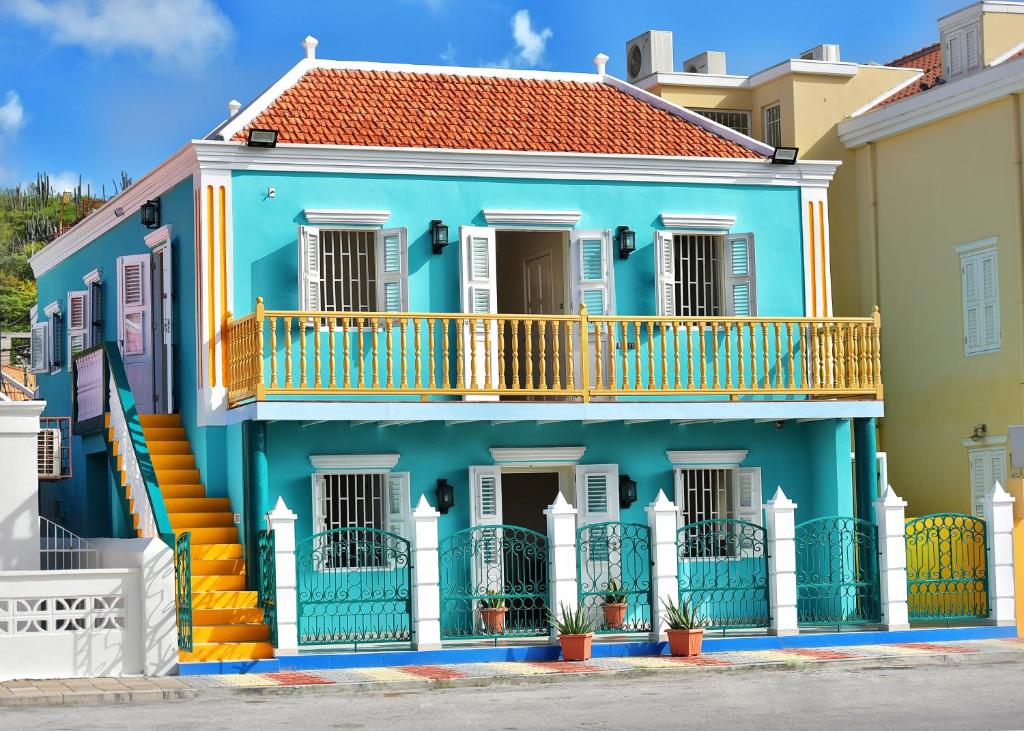 a blue house with a balcony at Turquoise B&B in Willemstad