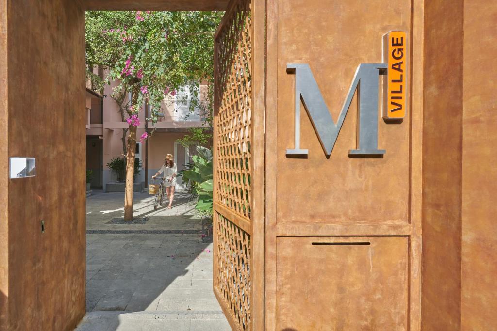 eine Tür mit dem Buchstaben n an der Seite eines Gebäudes in der Unterkunft M Village The Garden in Ho-Chi-Minh-Stadt