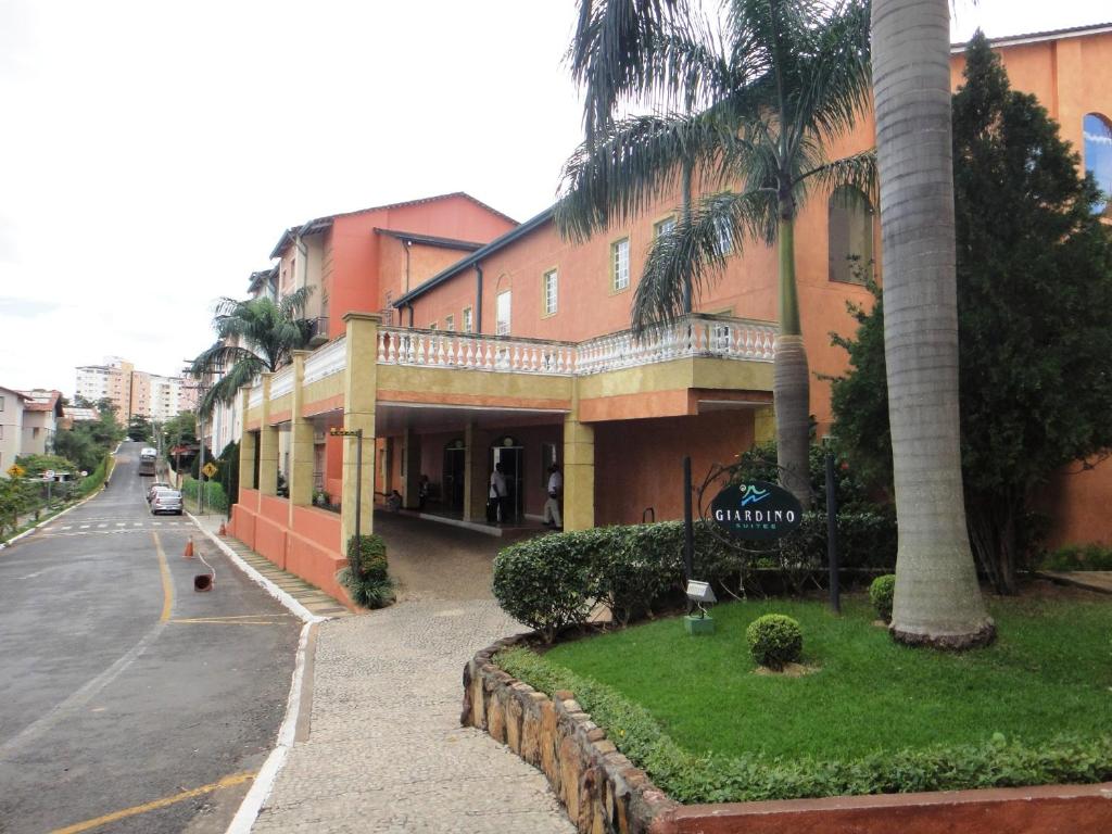 a building with palm trees on the side of a street at Hot Park - 400 metros in Rio Quente