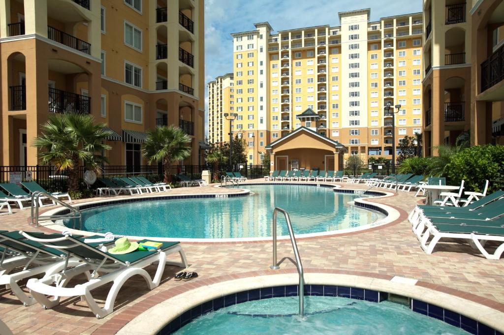 a swimming pool in a hotel with chairs and tables at Lake Buena Vista Resort Village and Spa, Near Disney in Orlando