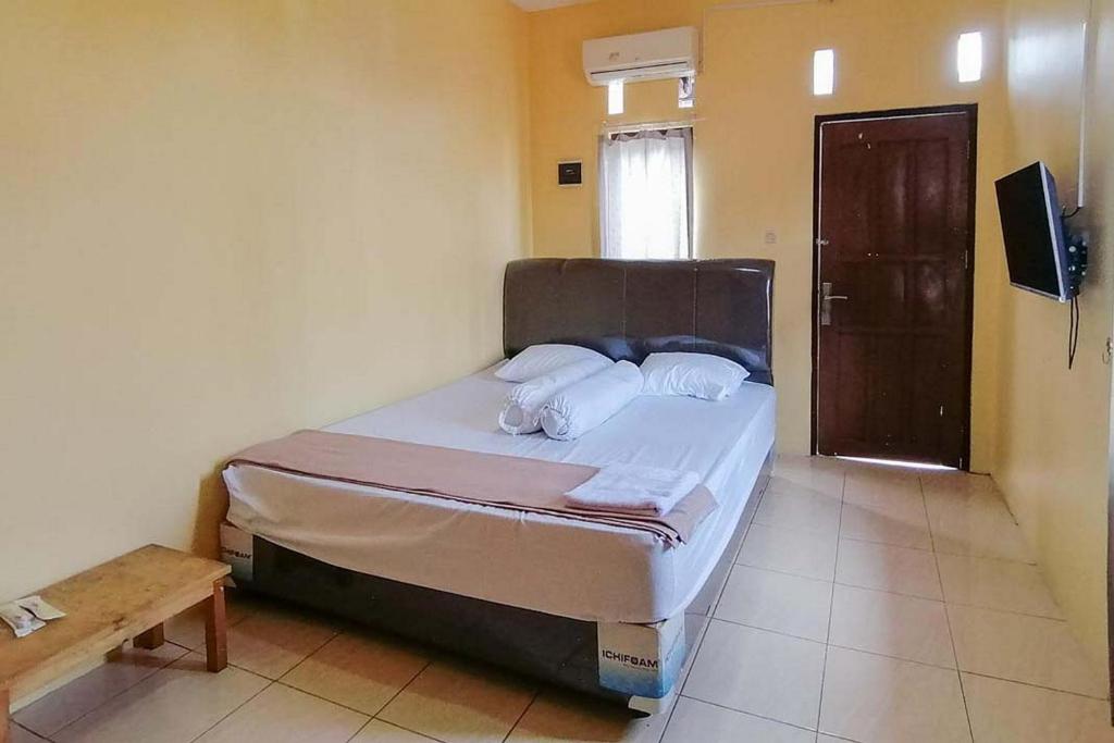 sypialnia z łóżkiem w pokoju w obiekcie Risqia Syariah TOD M1 Bandara Soekarno Hatta Mitra RedDoorz w mieście Sewan