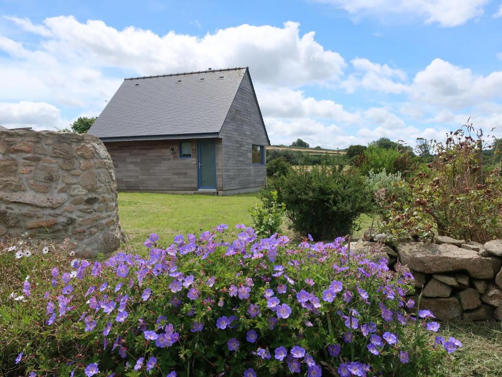 une maison avec des fleurs violettes devant dans l'établissement Wooden House in Brittany near Sandy Beach, à Landéda
