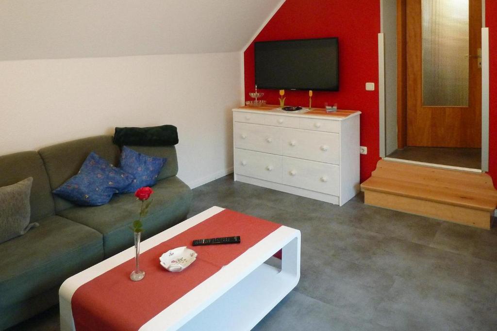 sala de estar con sofá y TV en Holiday Apartment An der Meiße, Bergen, en Bleckmar
