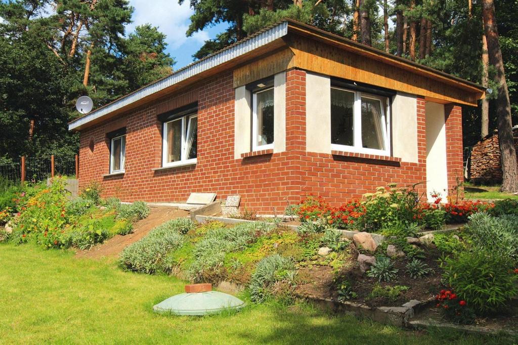 une petite maison en briques avec un jardin en face de celle-ci dans l'établissement Holiday home, Feldberg Lake District, à Wrechen