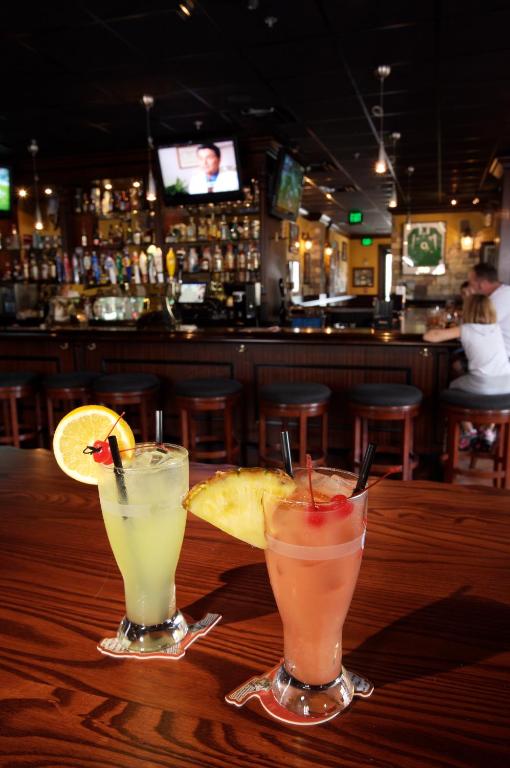 two cocktails sitting on a wooden table in a bar at Lake Buena Vista Resort Village and Spa, Near Disney in Orlando
