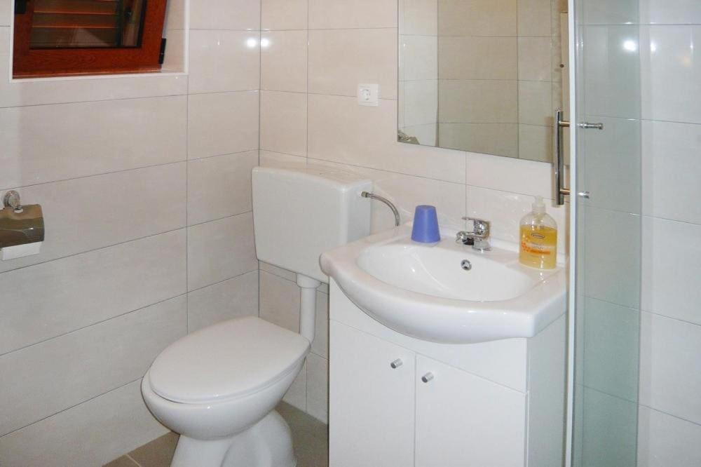 biała łazienka z toaletą i umywalką w obiekcie Apartment Zrinka in Starigrad Paklenica with terrace and seaview-ex TUI w mieście Starigrad-Paklenica