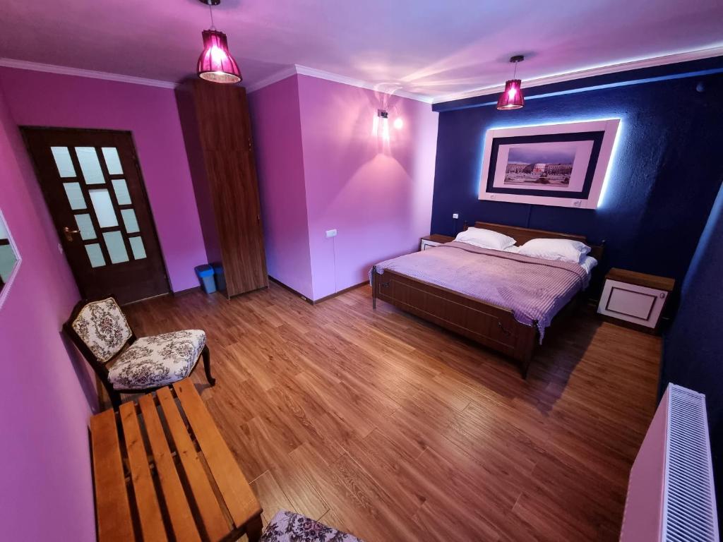 een paarse slaapkamer met een bed en een stoel bij Hrachy Mot - Gyumri in Gjoemri