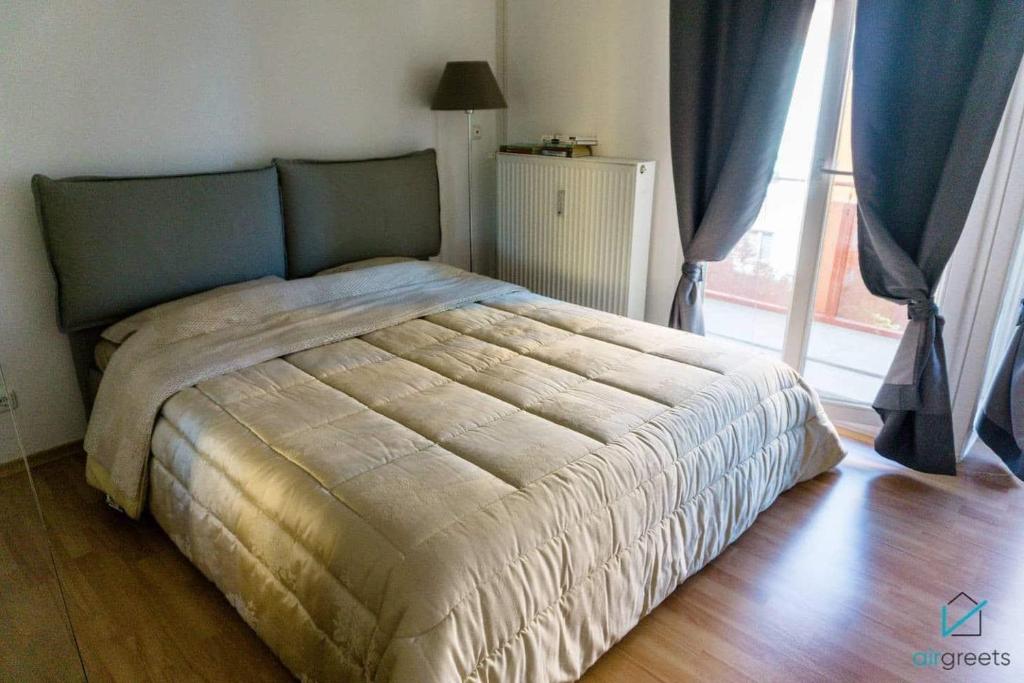 un grande letto in una camera da letto con finestra di Bright and Quiet Flat with a Balcony a Monaco