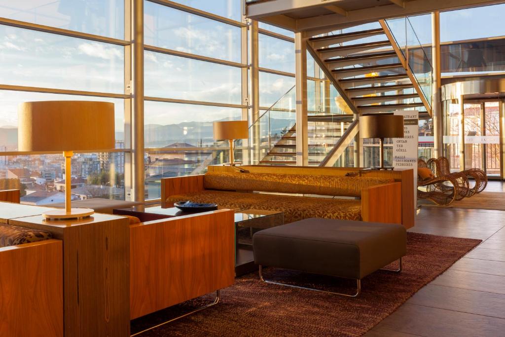 Habitación grande con escritorio y ventanas grandes. en Hotel Palau de Bellavista Girona by URH, en Girona