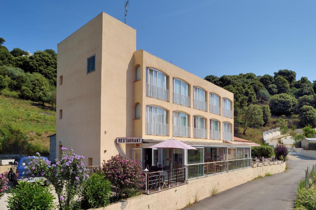 a building with an umbrella in front of it at Hotel Alata in Alata