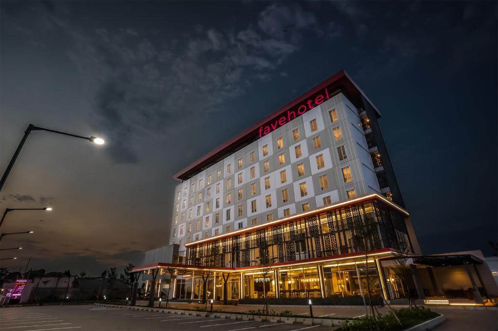a hotel with a lit up building at night at favehotel Pamanukan in Pamanukan-hilir