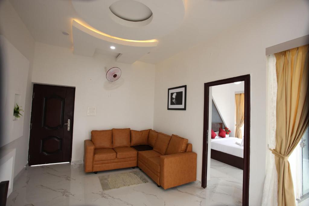 sala de estar con sofá y cama en Emirates Residency, en Pudunagaram