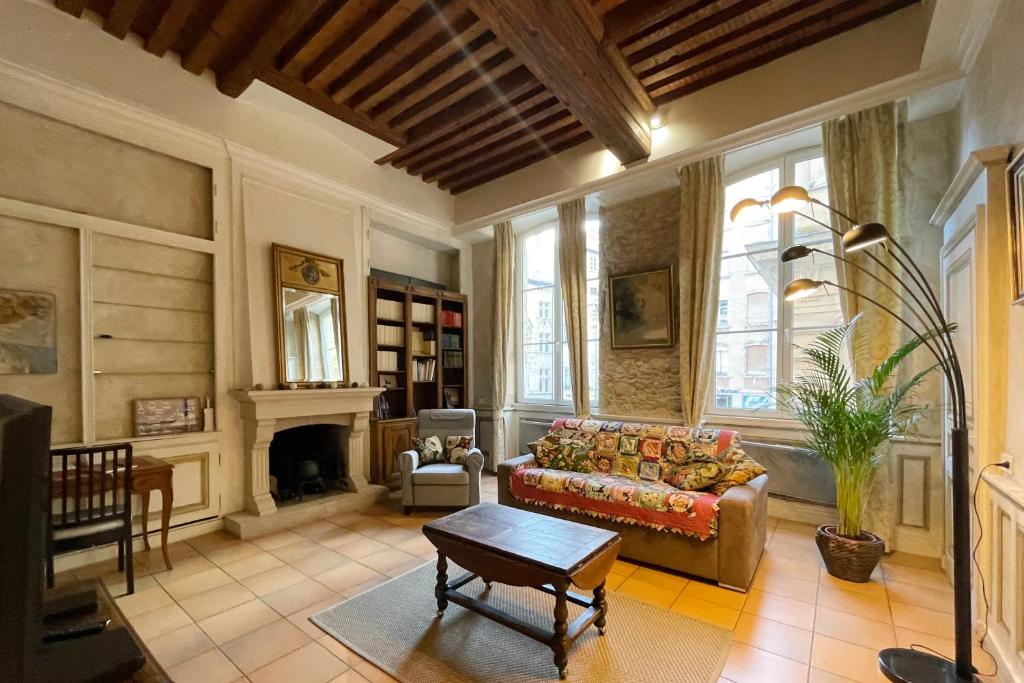 sala de estar con sofá y chimenea en Coeur Vieux Lyon, 60 M2 lumineux tout confort, en Lyon