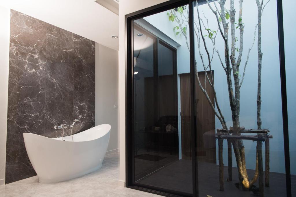 bagno con vasca bianca e doccia in vetro di VEVILLA a Bangkok