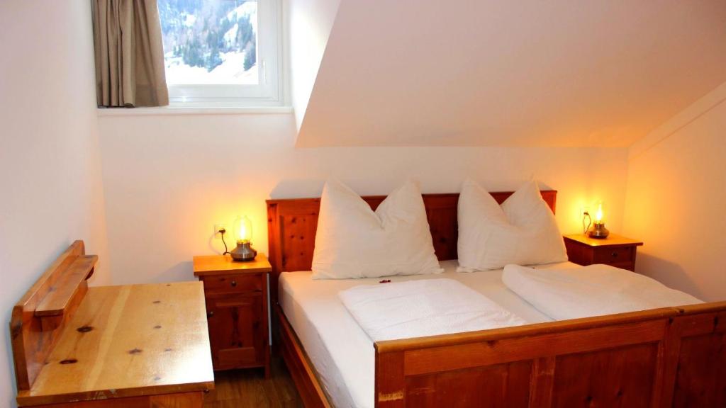 a bedroom with a bed with white pillows and a window at Sonnenhof in Kals am Großglockner