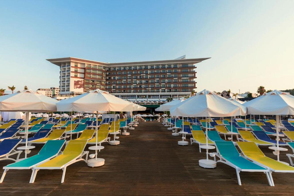 eine Reihe von Stühlen und Sonnenschirmen an einem Strand in der Unterkunft Mary Hotels Alanya in Alanya