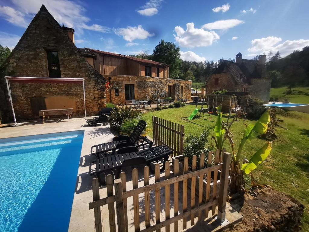 une villa avec une piscine et une maison dans l'établissement Gîte Les Combes Montignac Lascaux, à Montignac