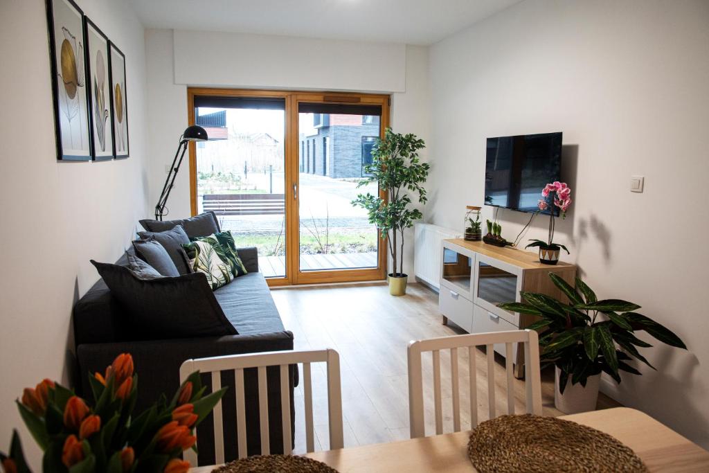 a living room with a couch and a tv at Maya's Flats & Resorts 18 - Nadmotlawie in Gdańsk