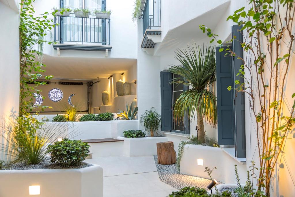 une cour avec des plantes en pot dans un bâtiment dans l'établissement Casona Seis Lunas Apartment, à Marbella