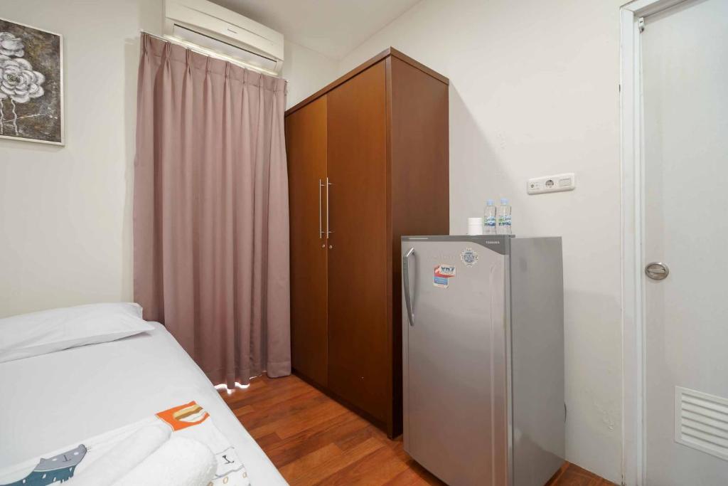 una camera con letto e frigorifero di Avalon Karawaci Mitra RedDoorz a Tangerang