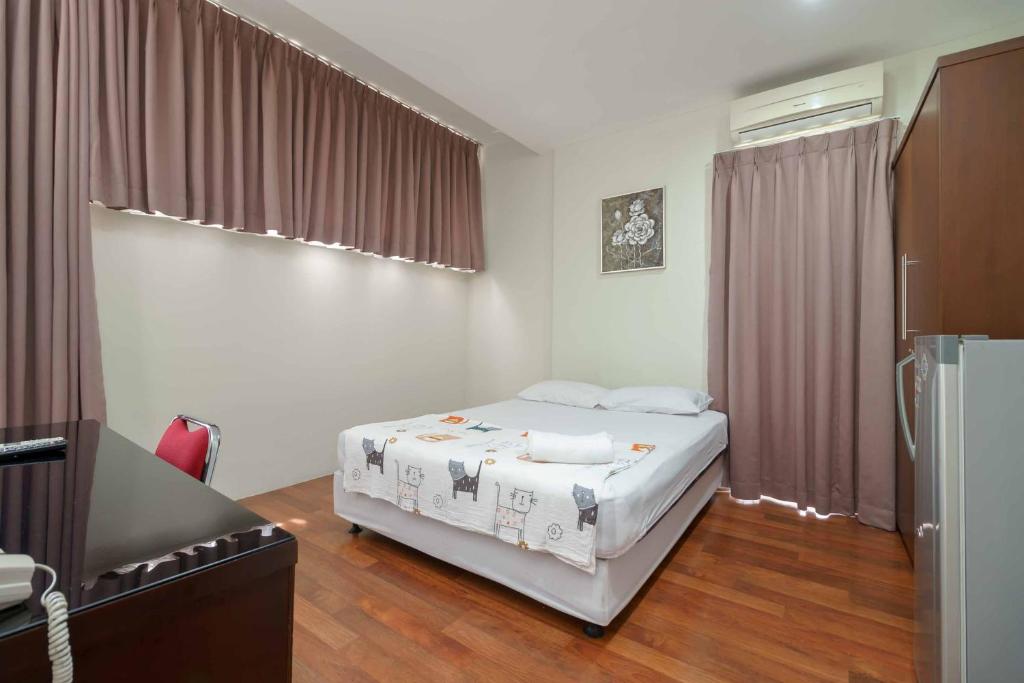 a bedroom with a bed and a couch in a room at Avalon Karawaci Mitra RedDoorz in Tangerang