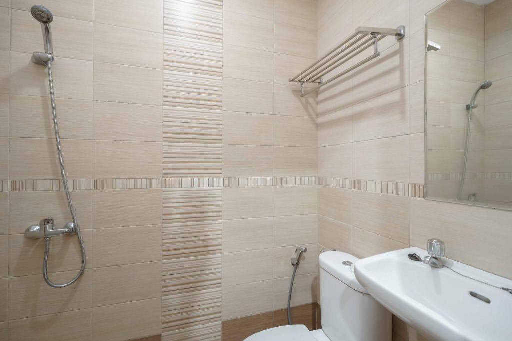 un bagno con doccia, WC e lavandino di Avalon Karawaci Mitra RedDoorz a Tangerang