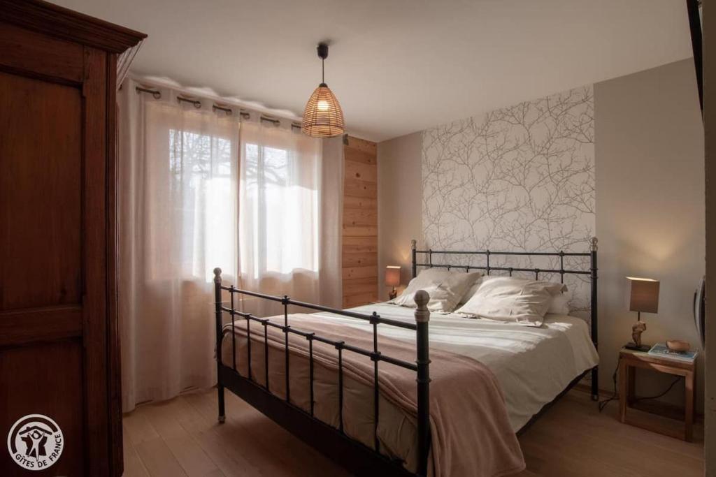 a bedroom with a large bed and a window at Le Berceau Savoyard - Annecy in Nâves-Parmelan