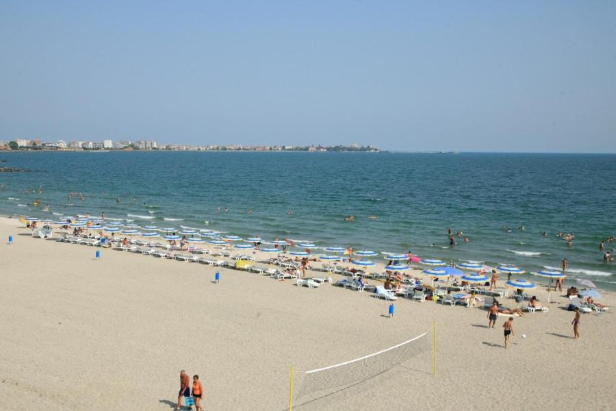 a group of people on a beach with umbrellas at Festa Studio in Pomorie