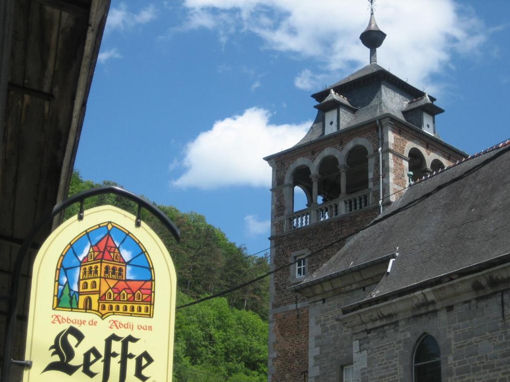 um sinal no lado de um edifício com uma torre em Magnifiques chambres d'hôtes au grand air em Anhée