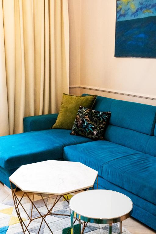 a blue couch in a living room with two tables at Maya's Flats & Resorts 44 - 3 rooms apartment on Chlebnicka Street Gdańsk Old Town in Gdańsk