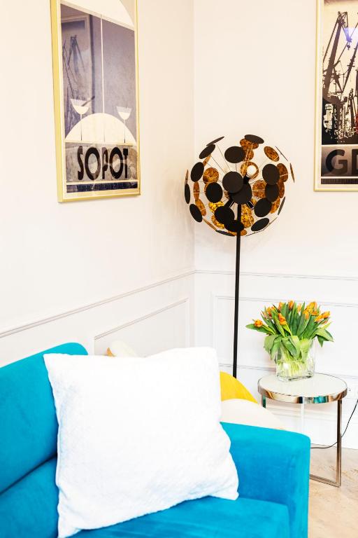 a blue couch in a living room with a lamp at Maya's Flats & Resorts 44 - 3 rooms apartment on Chlebnicka Street Gdańsk Old Town in Gdańsk