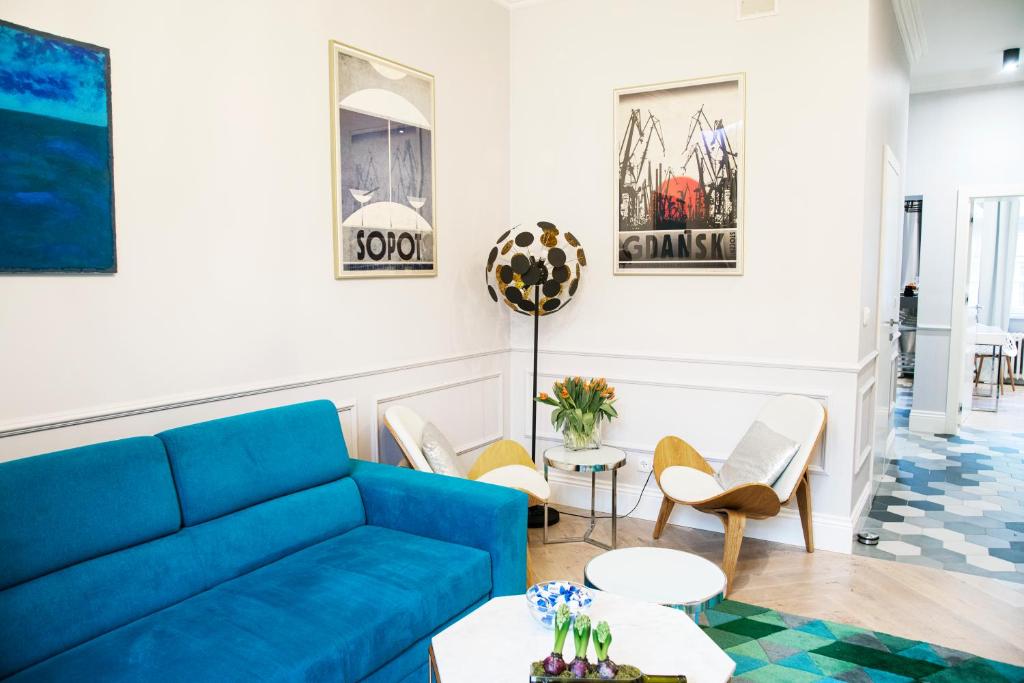 sala de estar con sofá azul y sillas en Maya's Flats & Resorts 44 - Chlebnicka 17/18, en Gdansk