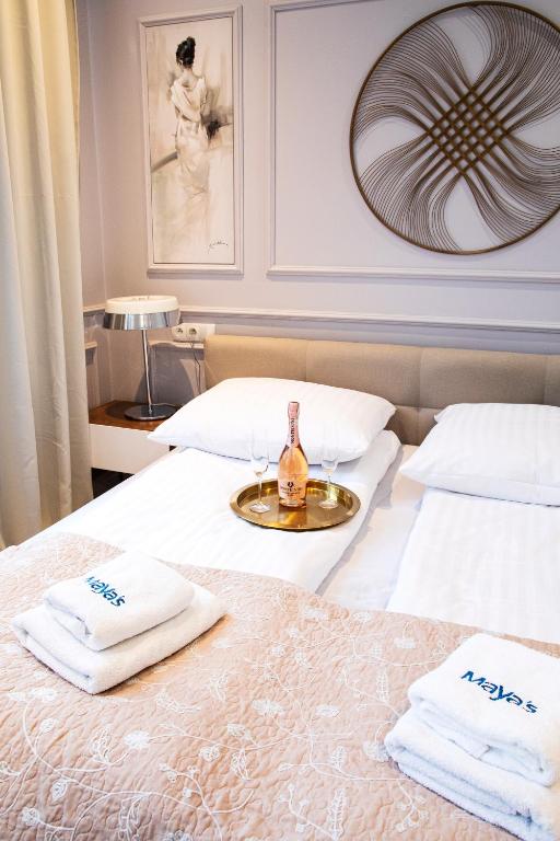 a hotel room with two beds with towels and a bottle of wine at Maya's Flats & Resorts 44 - 3 rooms apartment on Chlebnicka Street Gdańsk Old Town in Gdańsk