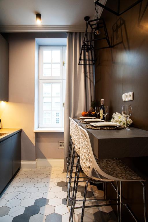 a kitchen with a table with chairs and a window at Maya's Flats & Resorts 44 - 3 rooms apartment on Chlebnicka Street Gdańsk Old Town in Gdańsk
