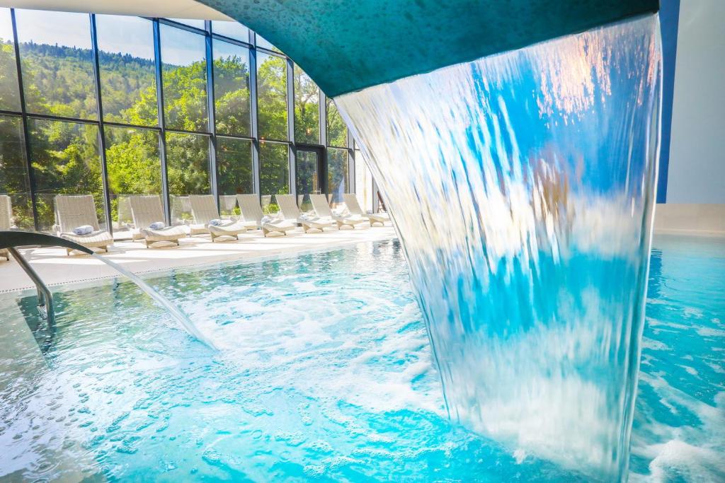 una piscina en un hotel con una fuente de agua en Magnus Resort, en Szczyrk